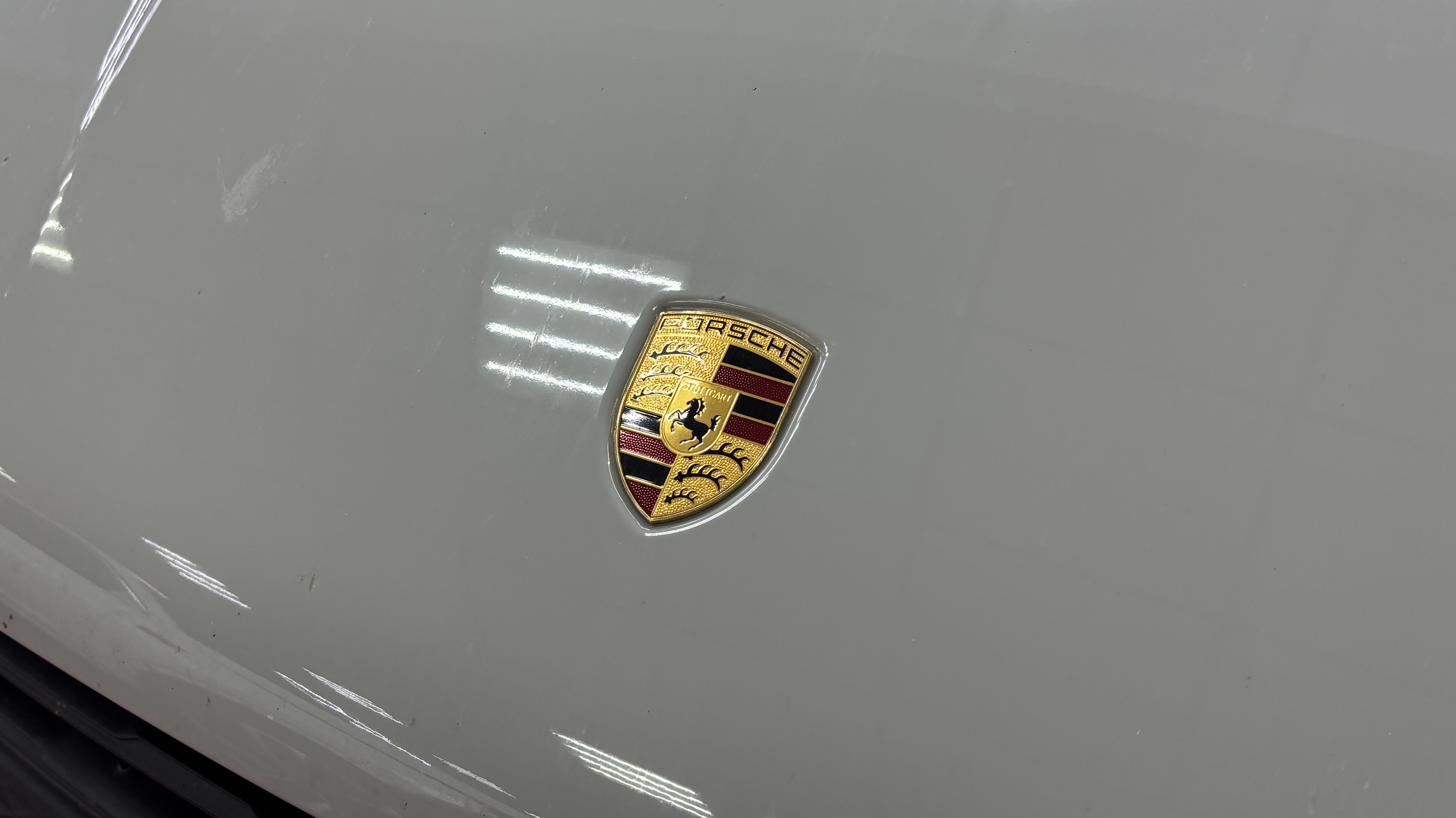 Деталь кузова Porsche Macan S с фирменной эмблемой