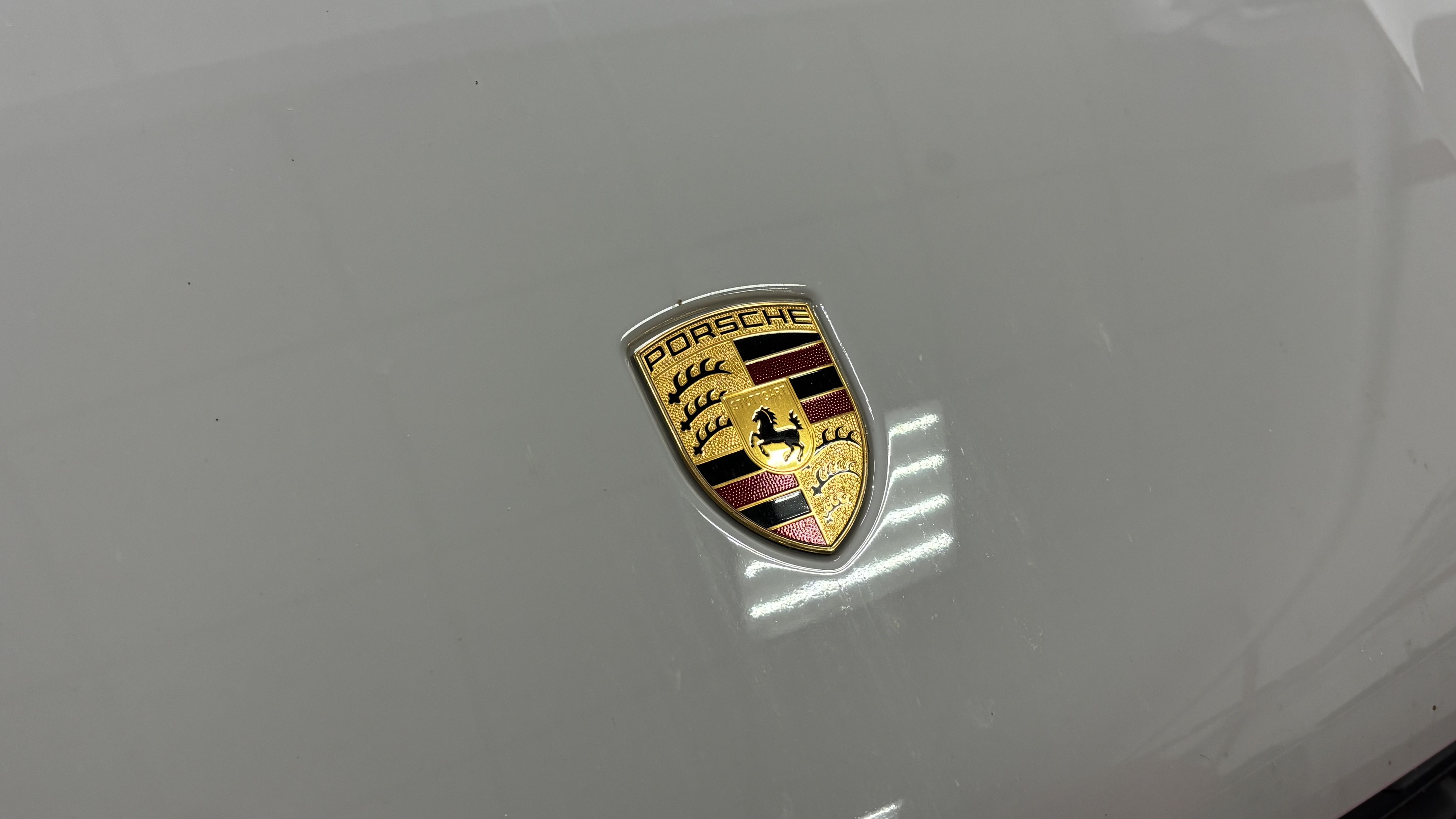 Фирменная эмблема Porsche на кузове Macan S